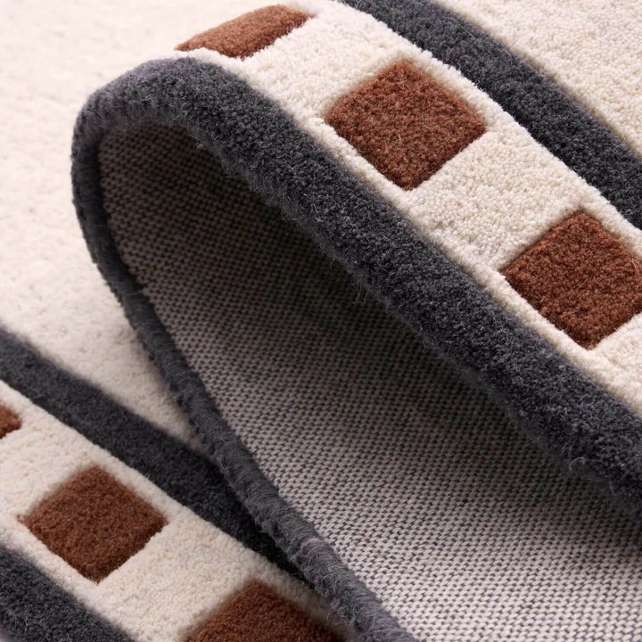 Close-up of a textured rug with geometric pattern on a light background