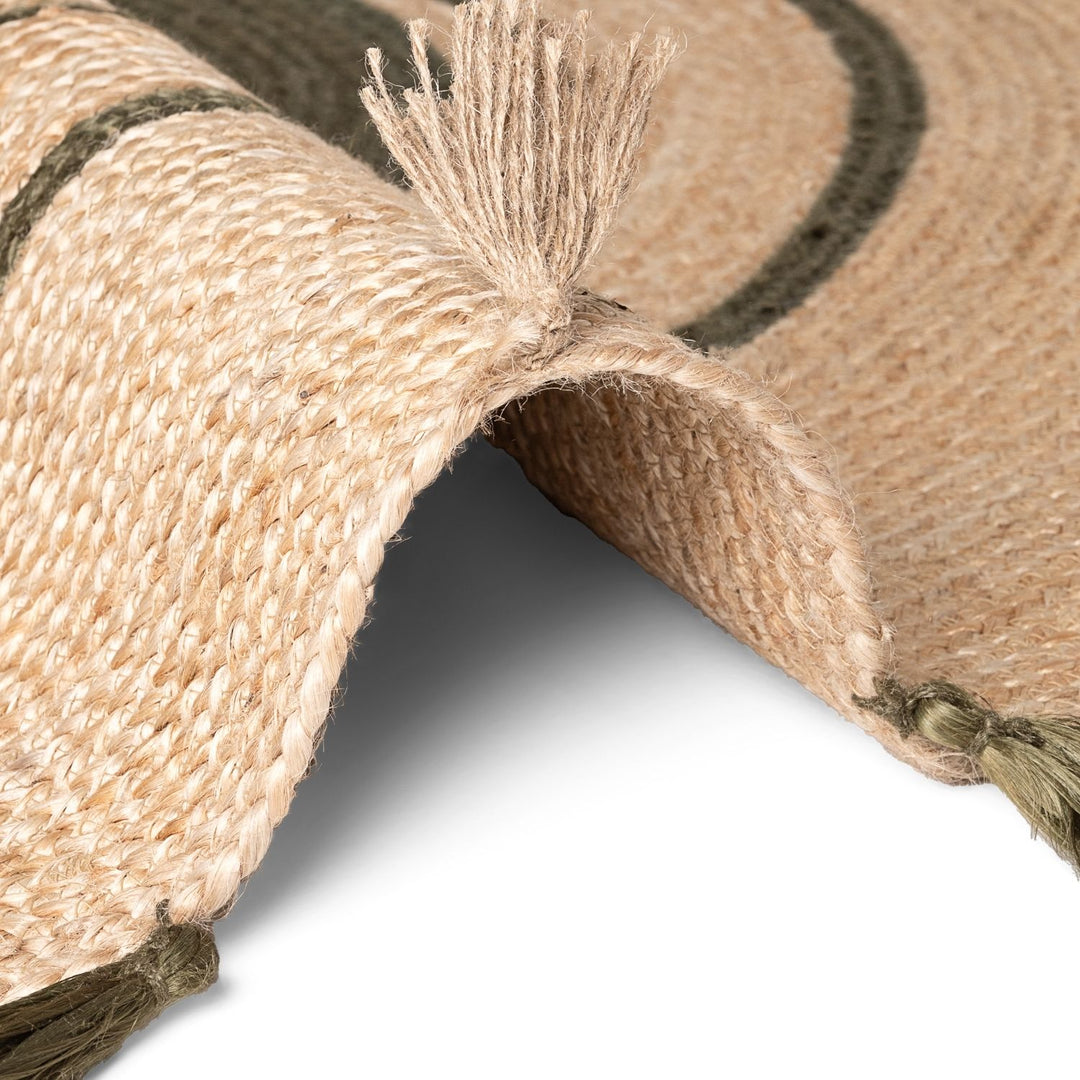 Close-up of a woven mat with tassels on a white background