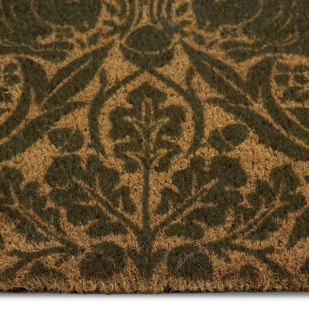 Close-up of a textured brown doormat with a leaf pattern