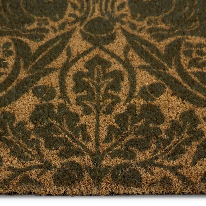 Close-up of a textured brown doormat with a leaf pattern