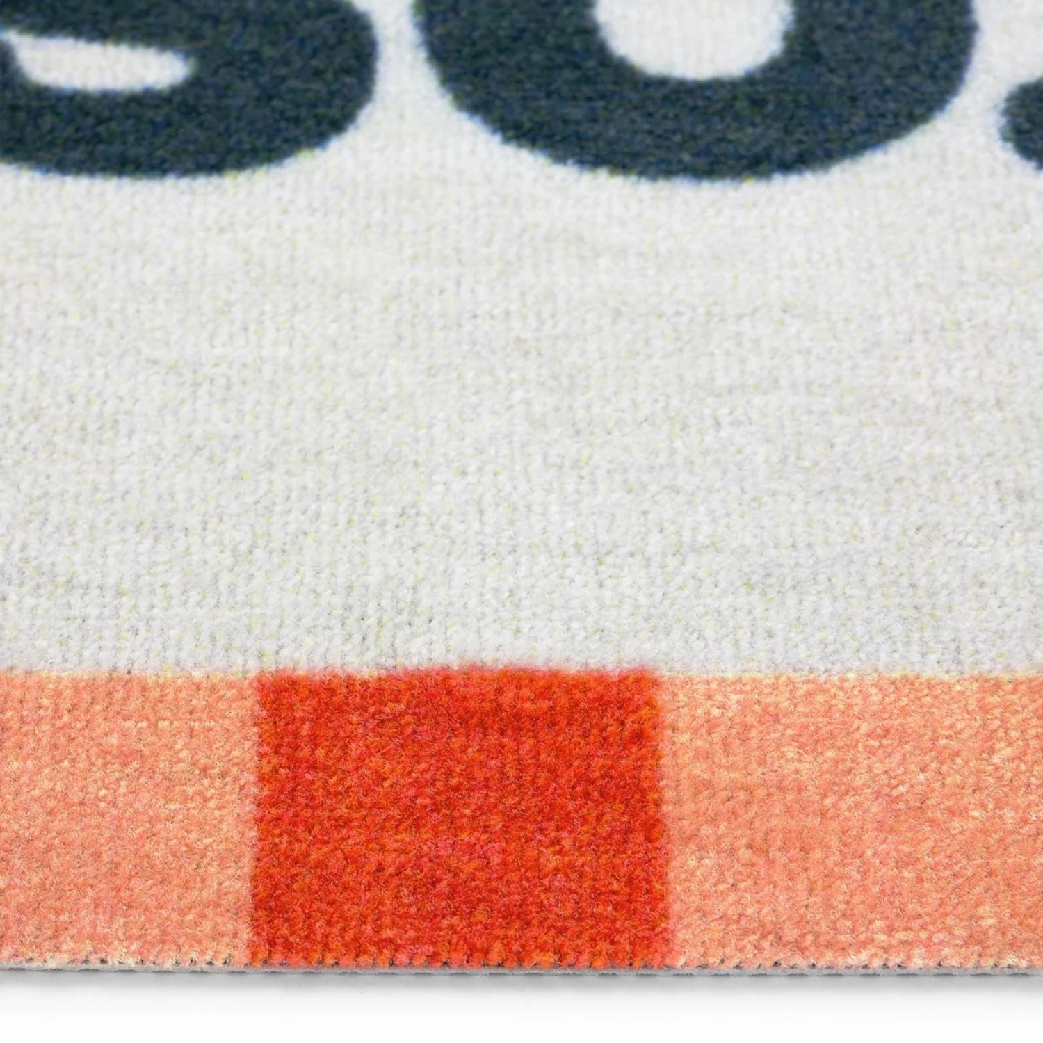 Close-up of a textured surface with a red square and blurred text in the background