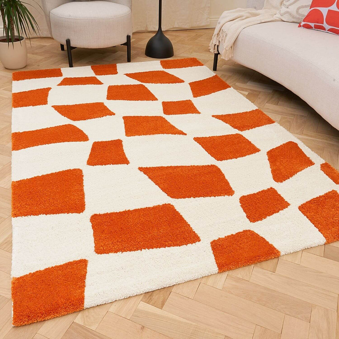 Orange and white geometric patterned rug on a wooden floor