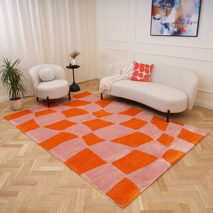 Living room with a geometric patterned rug, white sofa, and abstract painting.