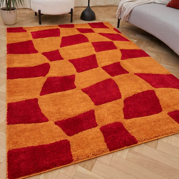 Red and orange checkered rug on a wooden floor