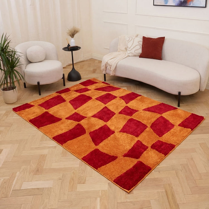 Living room with a checkered red and orange rug, white sofa, and armchair.