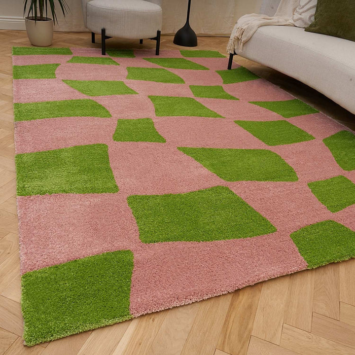 Pink and green checkered rug on a wooden floor
