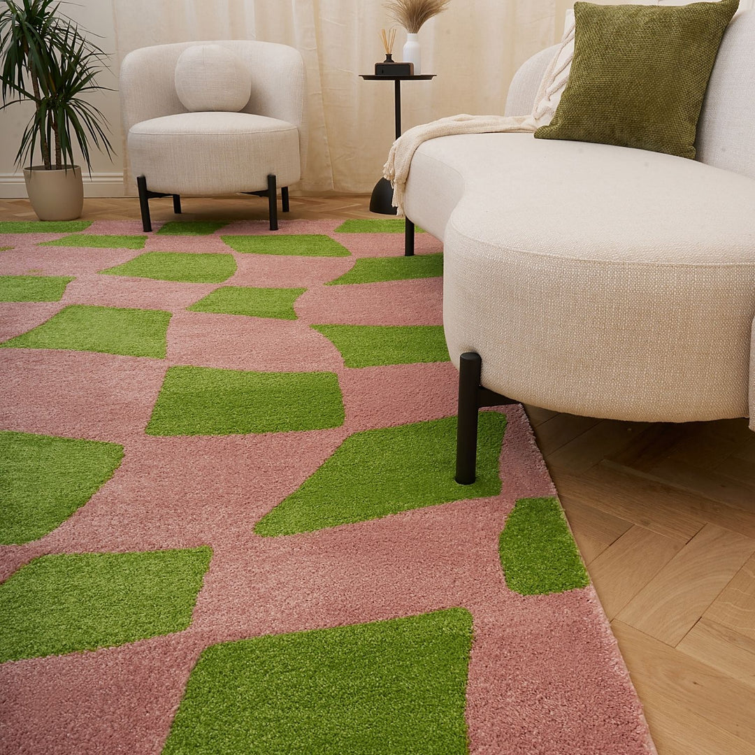 Living room with a pink and green checkered rug, beige sofa, and white armchair.