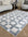 Checkered area rug on a wooden floor with a living room setting.