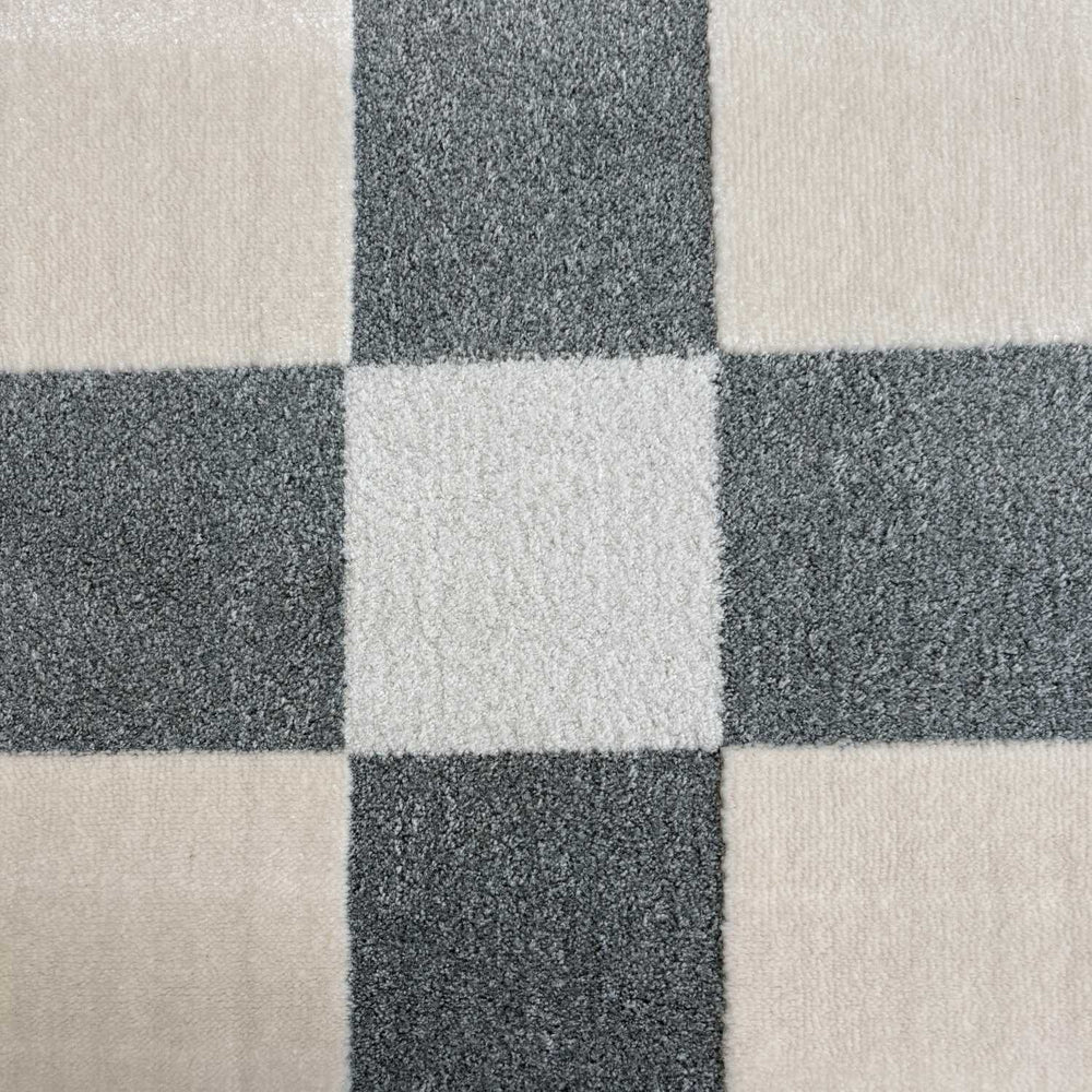 Close-up of a checkered pattern with alternating dark gray and beige squares.