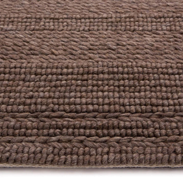 Close-up of a brown textured rug on a white background