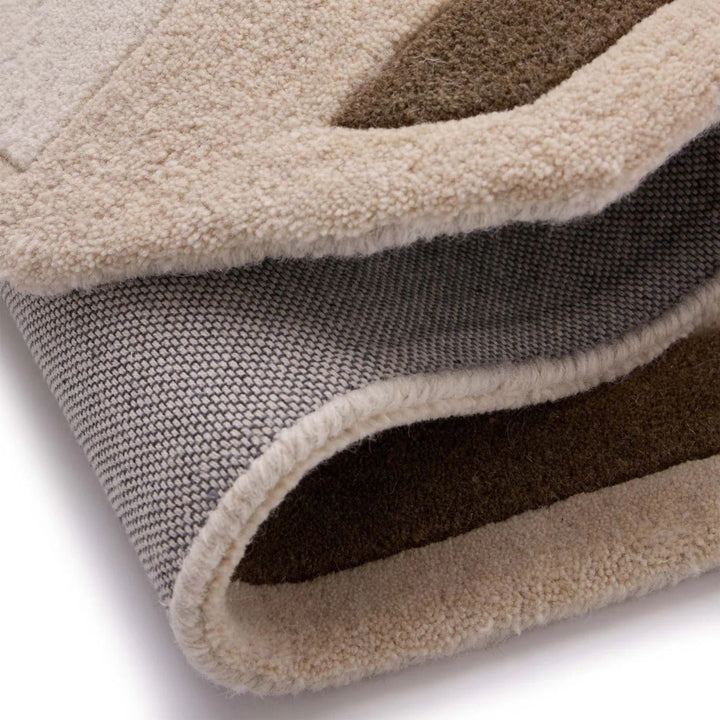 Close-up of a textured rug with a neutral color palette on a white background