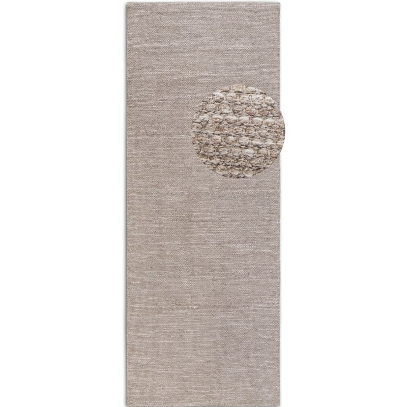 Textured area rug with a circular pattern in the center on a plain background