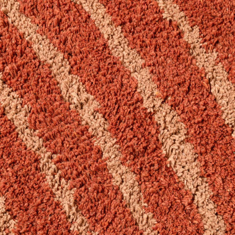 Close-up of a textured red and beige carpet
