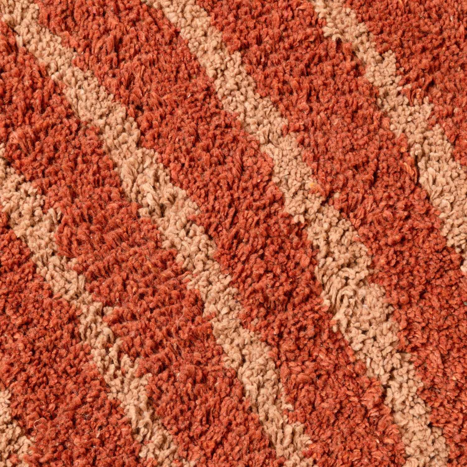 Close-up of a textured red and beige carpet