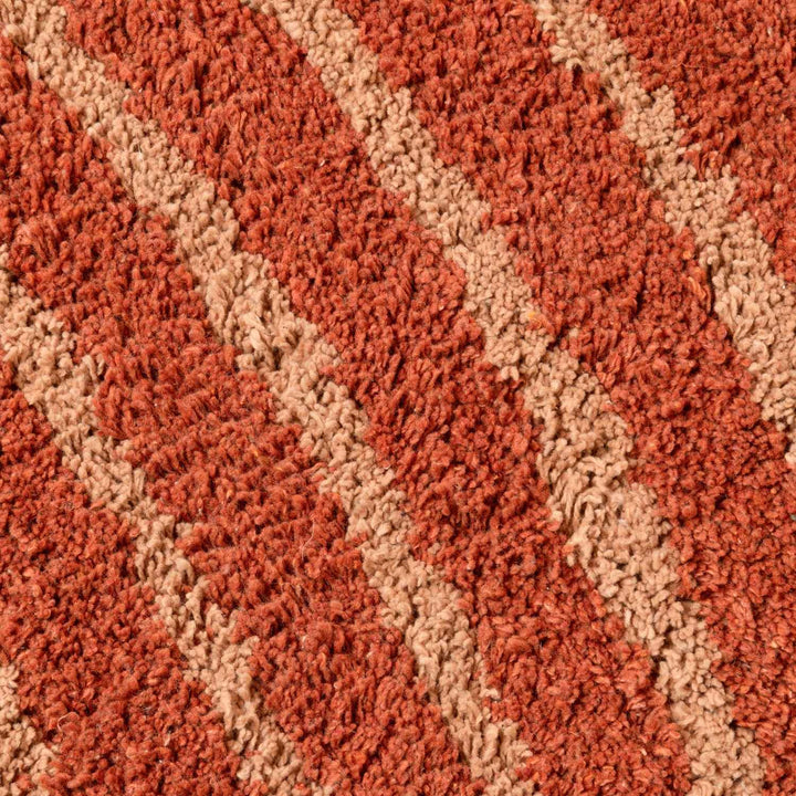 Close-up of a textured red and beige carpet