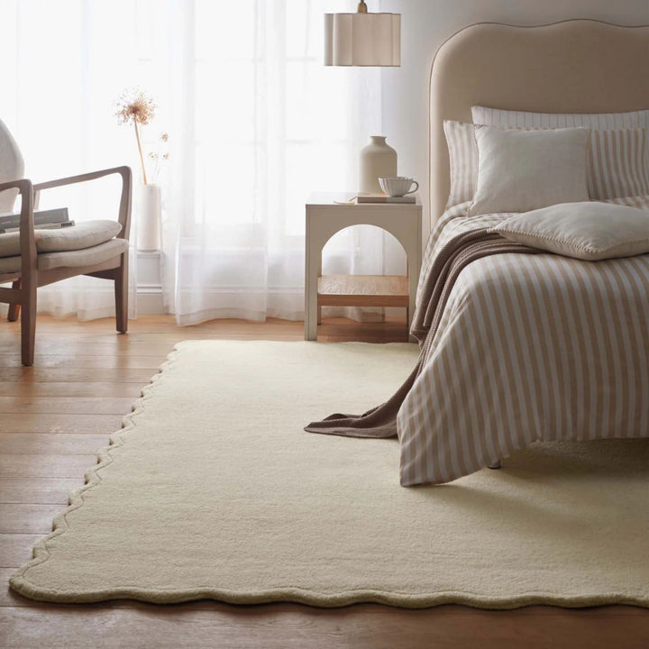 Neatly made bed with striped bedding in a bedroom setting.