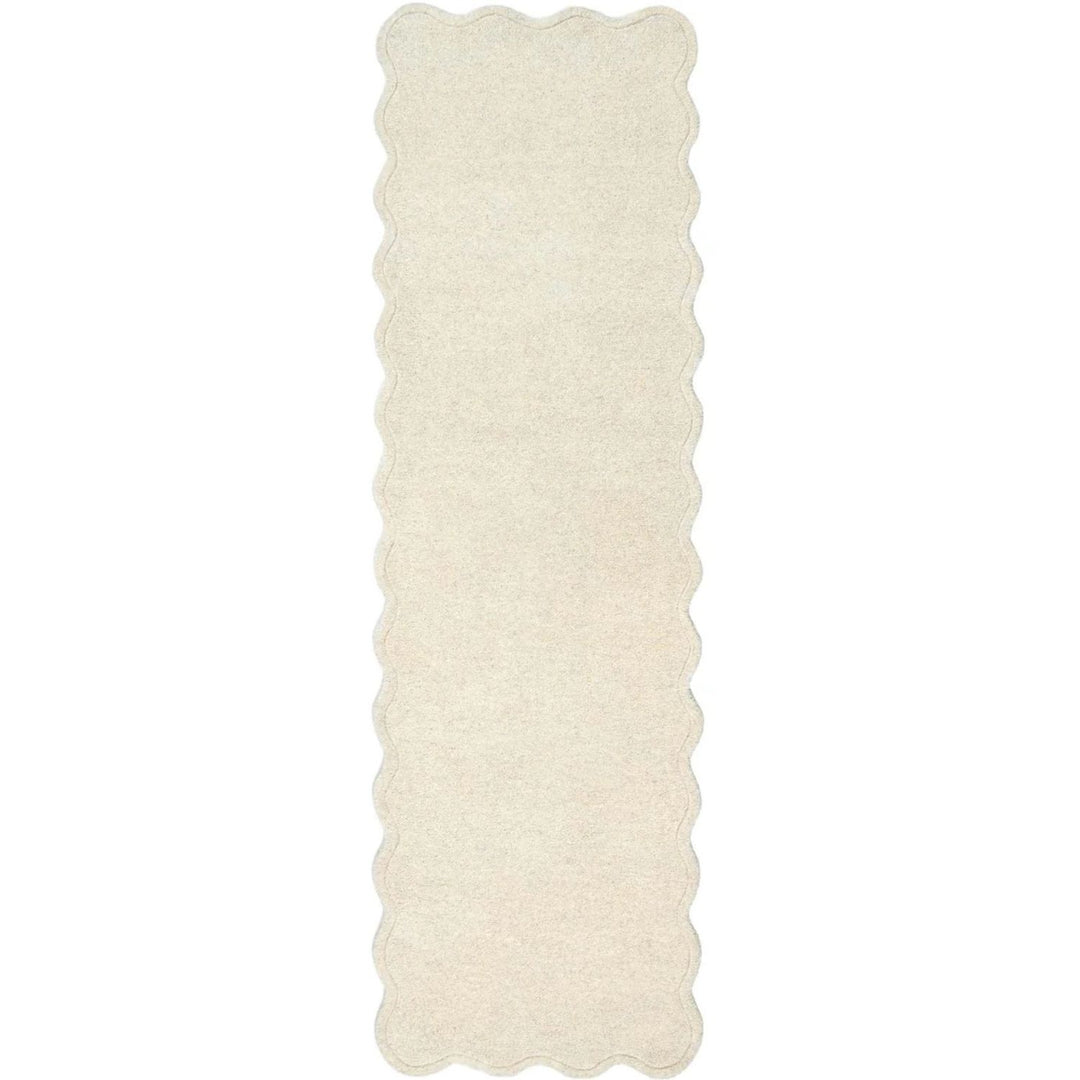 Rectangular white rug with scalloped edge on a white background
