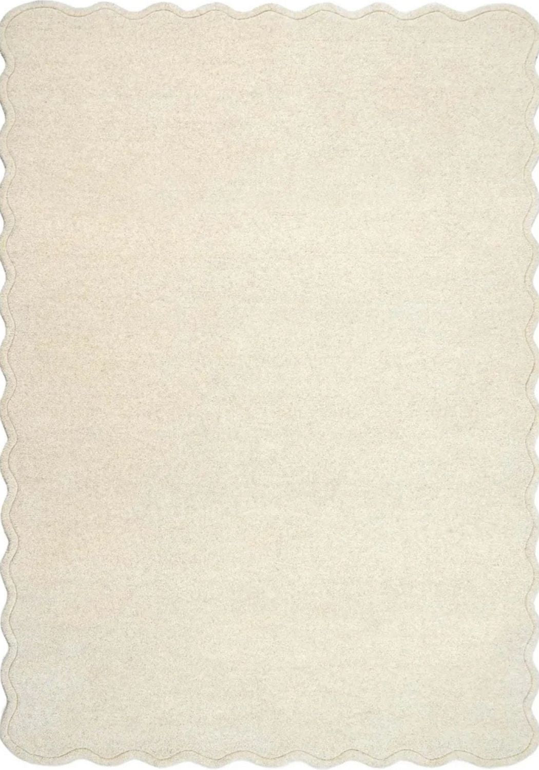 Beige rug with scalloped edge on a white background