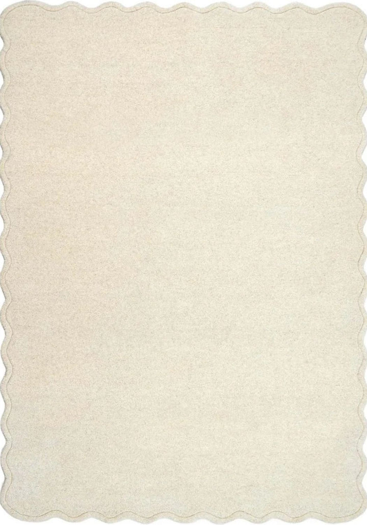 Beige rug with scalloped edge on a white background