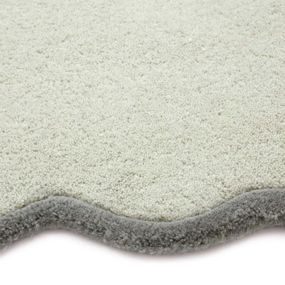 Close-up of a textured gray rug corner on a white background