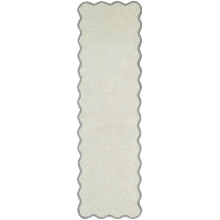 Rectangular white rug with scalloped edge on a white background