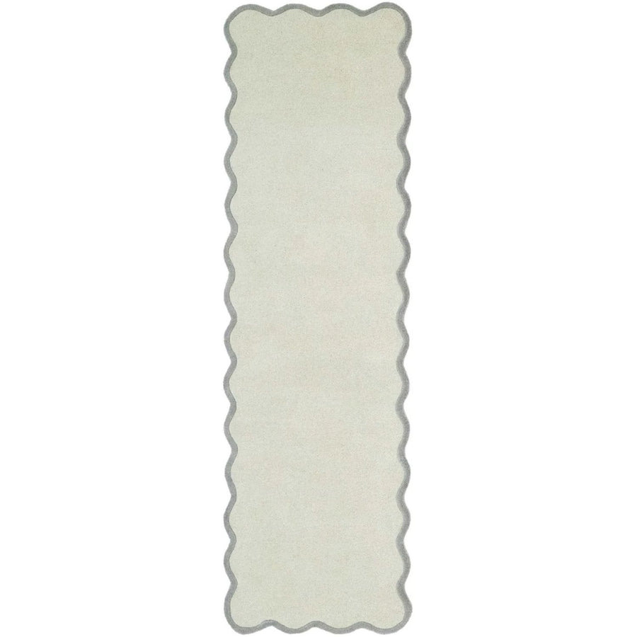 Rectangular white rug with scalloped edge on a white background