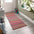 Colorful striped rug on a wooden floor with a white door and plant in the background