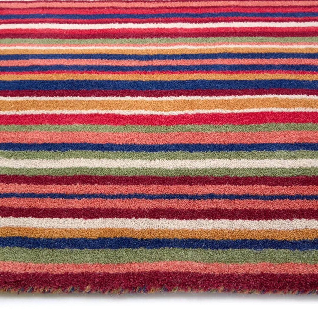 Multicolored striped rug with red, blue, green, and orange stripes on a white background
