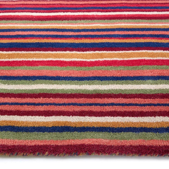 Multicolored striped rug with red, blue, green, and orange stripes on a white background
