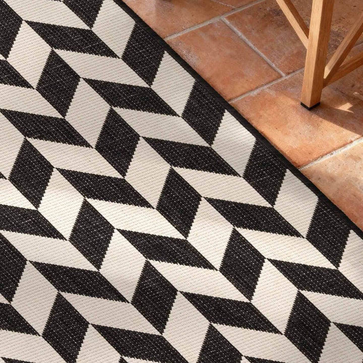 Black and white geometric patterned rug on a tiled floor