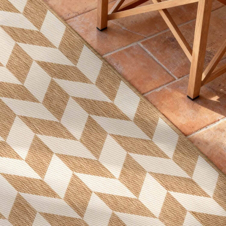 Geometric patterned rug on a terracotta tiled floor with wooden furniture.