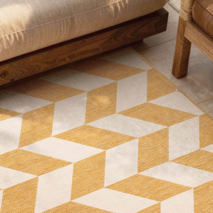 Geometric patterned rug with yellow and white colors on a floor.
