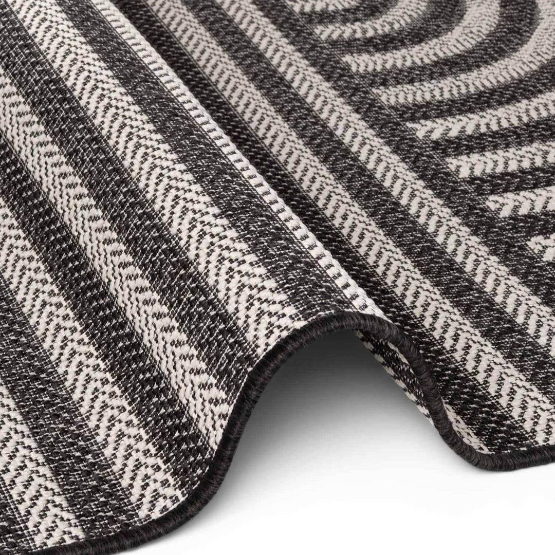 Close-up of a textured black and white patterned rug on a white background