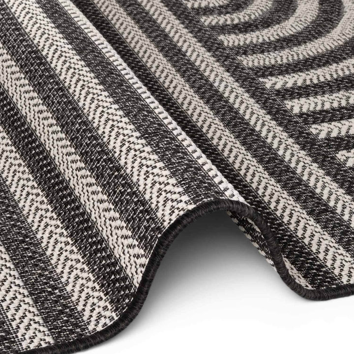 Close-up of a textured black and white patterned rug on a white background