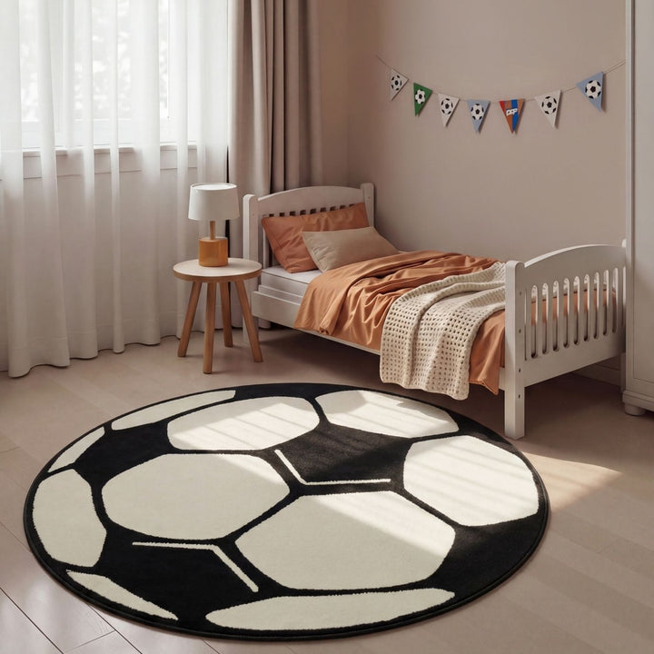 Children's bedroom with a soccer ball-shaped rug, bed, and small table.