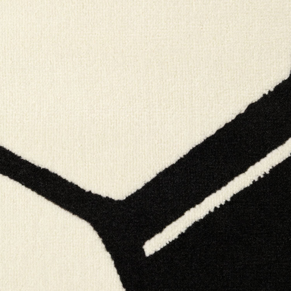 Close-up of a black and white patterned rug with geometric shapes.