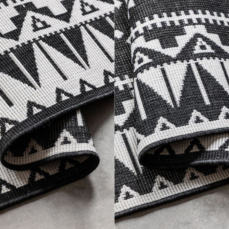 Close-up of a black and white patterned rug on a neutral background