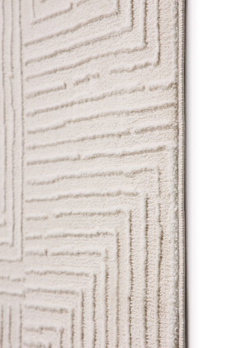 Close-up of an abstract geometric rug in cream shades, featuring clean lines and a textured surface.