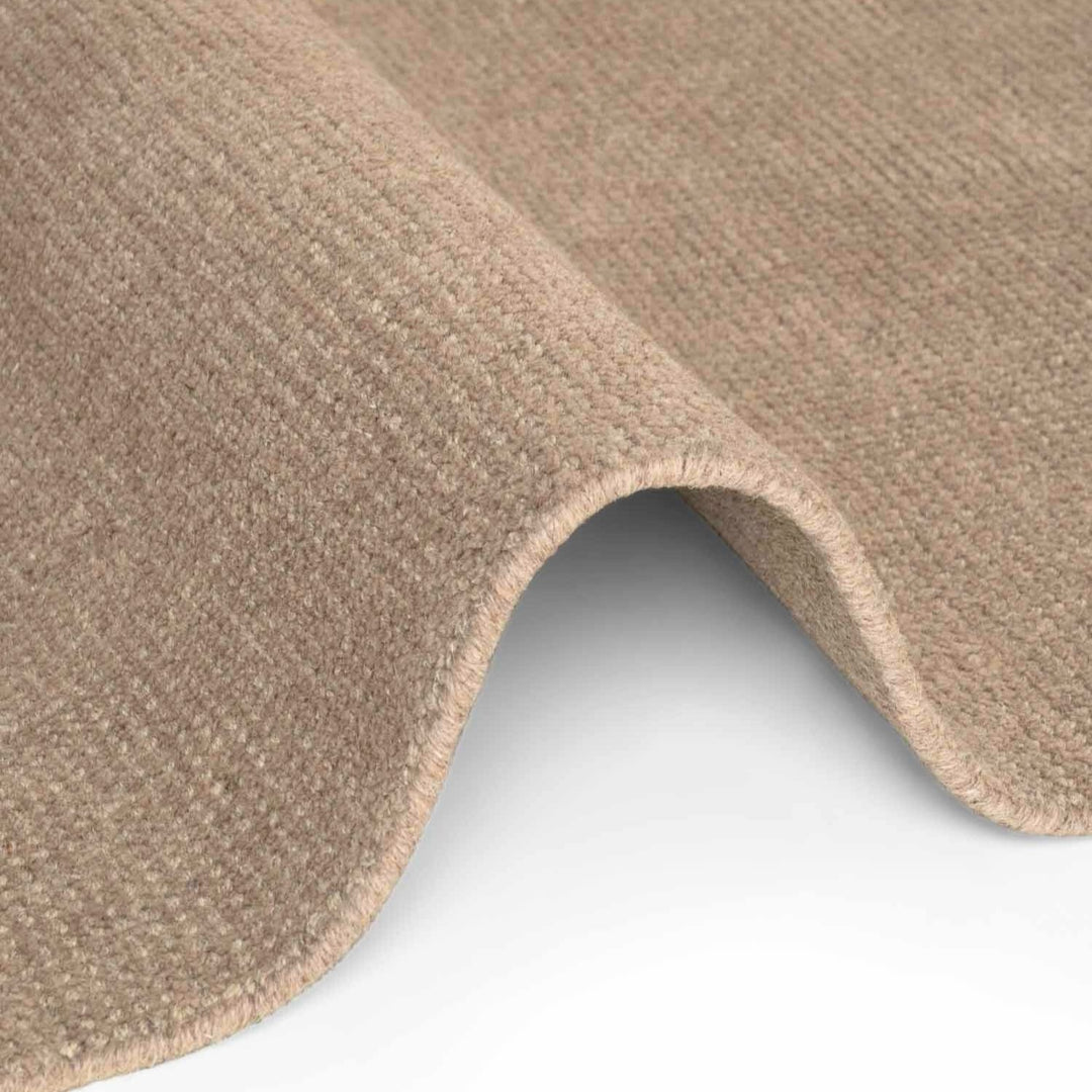 Close-up of beige carpet texture on a white background