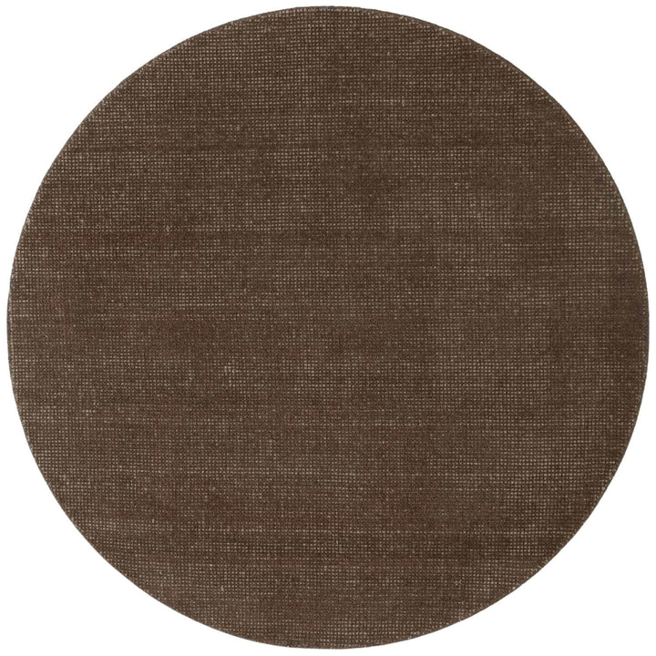 Round brown rug with a textured surface on a white background