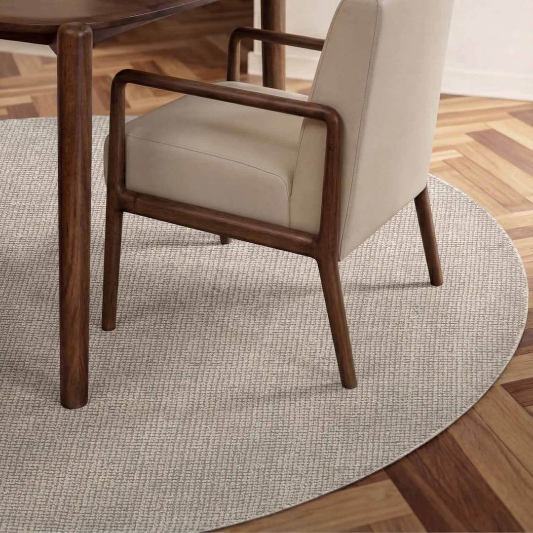 Beige armchair with wooden frame on a round gray rug
