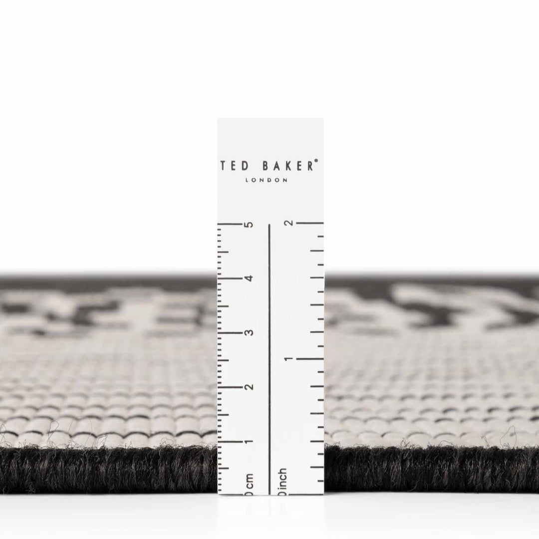 Black and white patterned rug with a ruler for scale and 'Ted Baker' branding.