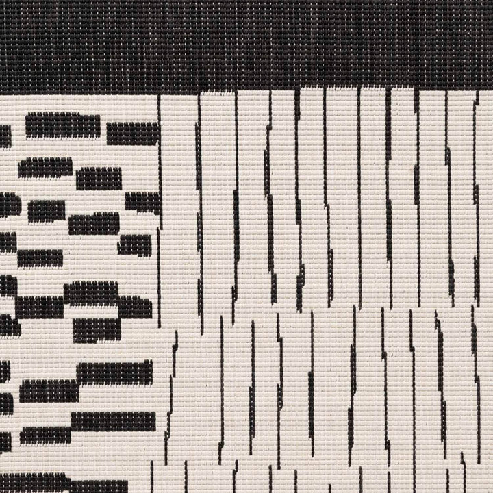 Close-up of a woven pattern with black and white stripes on a textured background