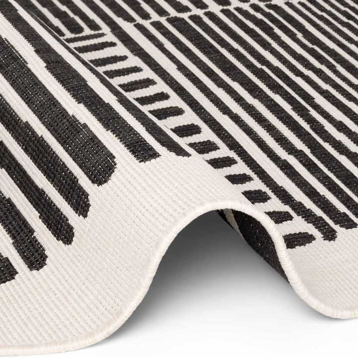 Close-up of a black and white patterned rug with geometric design.