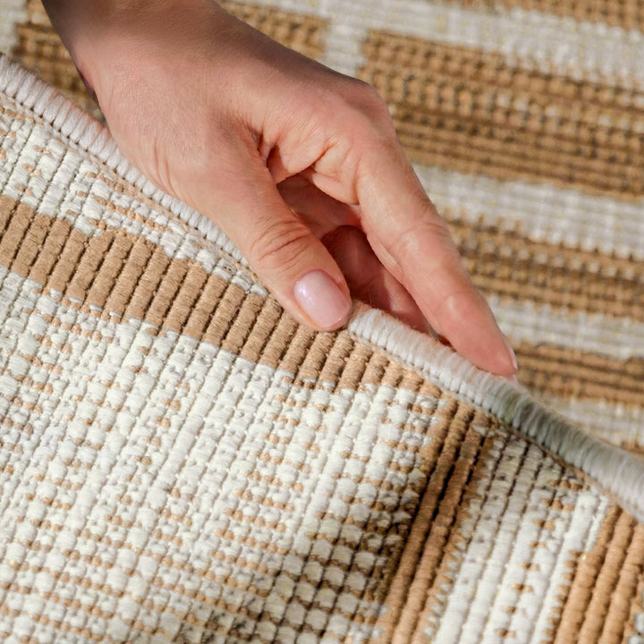 Hand touching a woven beige and white rug