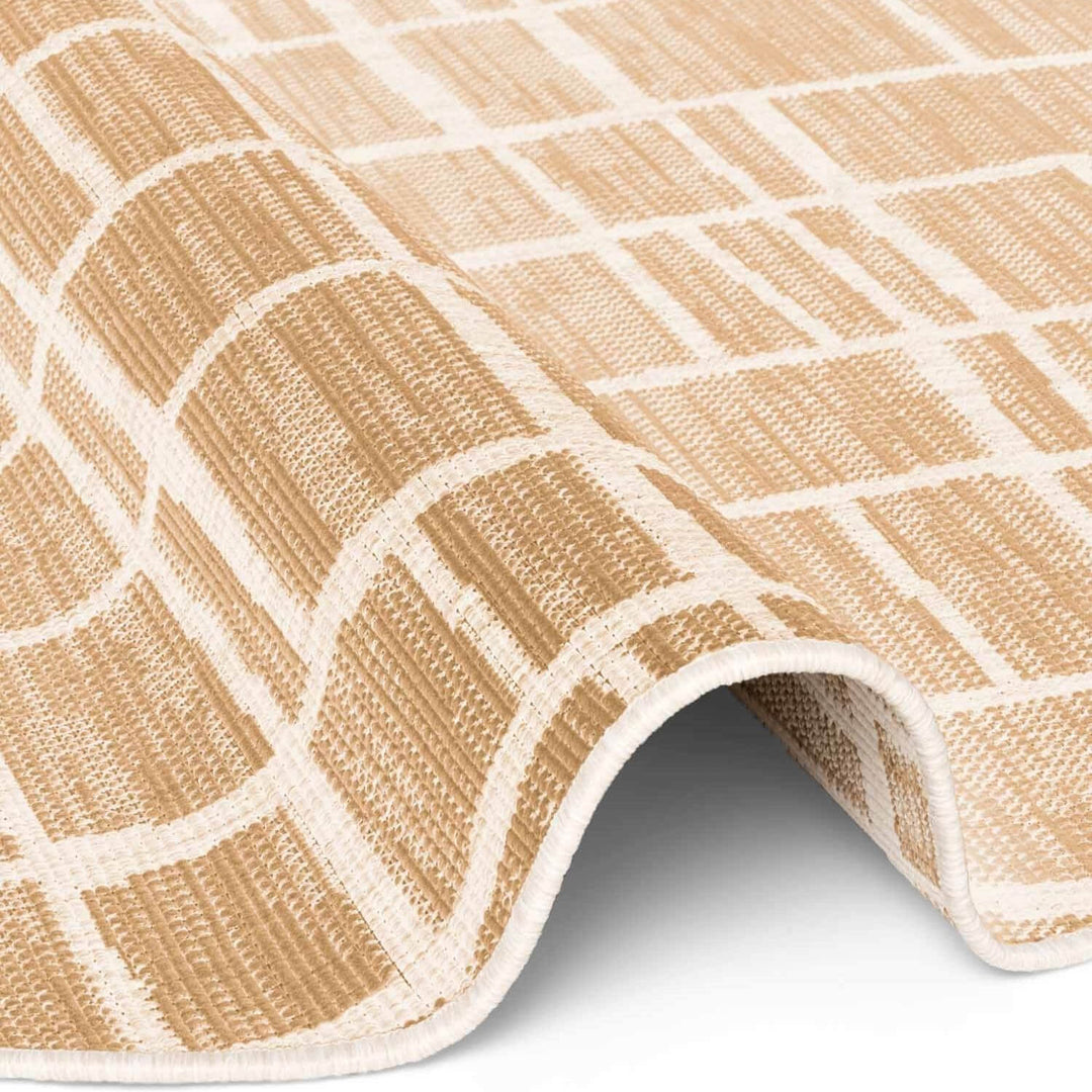 Close-up of a beige and white checkered rug on a plain background
