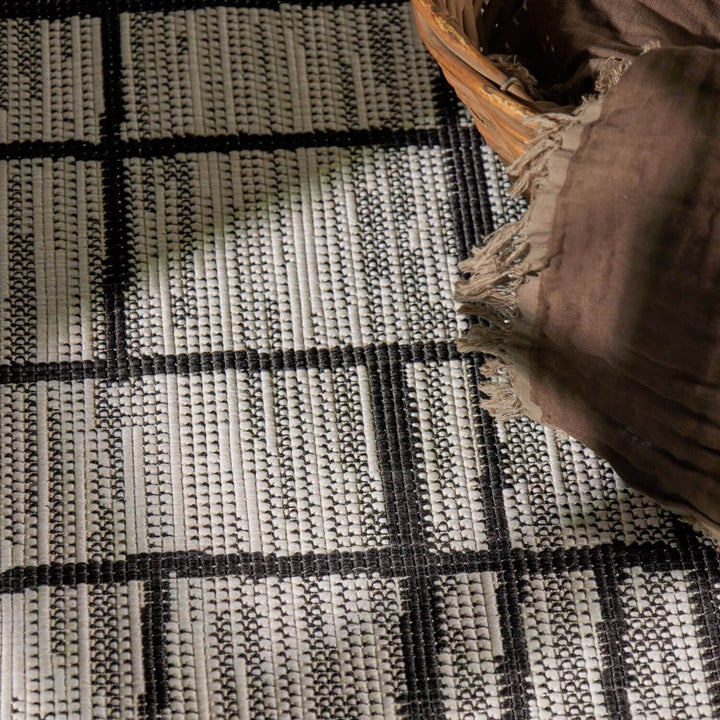 Close-up of a woven rug with a basket on top