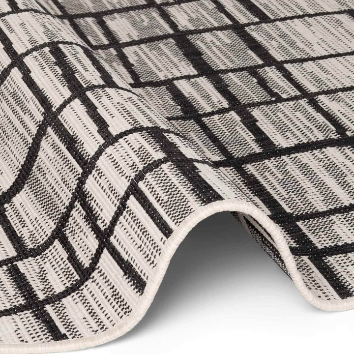 Close-up of a black and white checkered rug on a white background