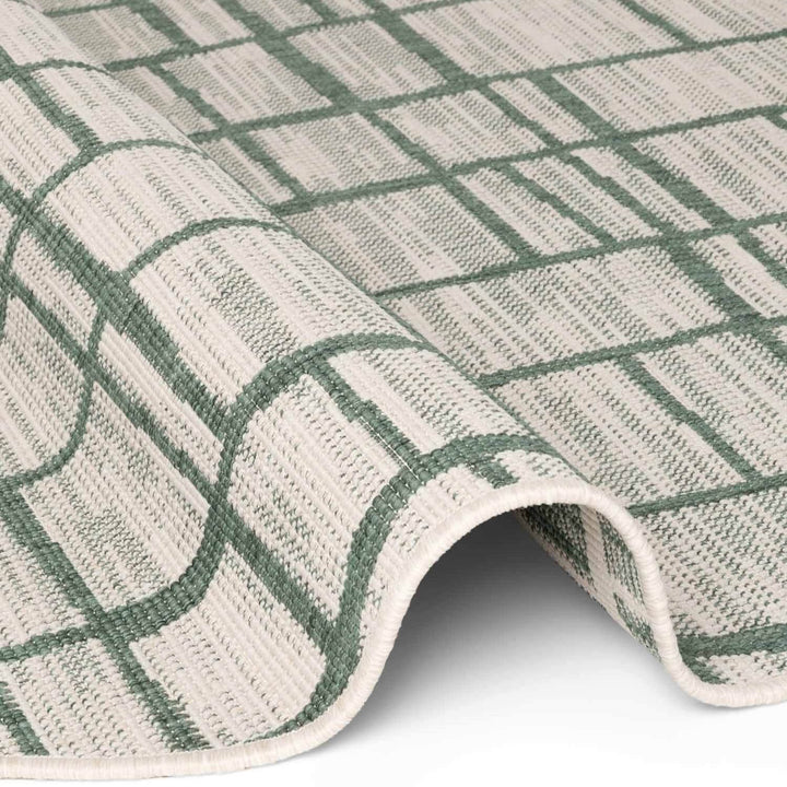 Close-up of a green and beige checkered rug on a white background