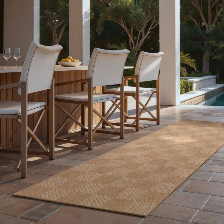 Outdoor patio setting with wooden chairs and a rug on a tiled floor.